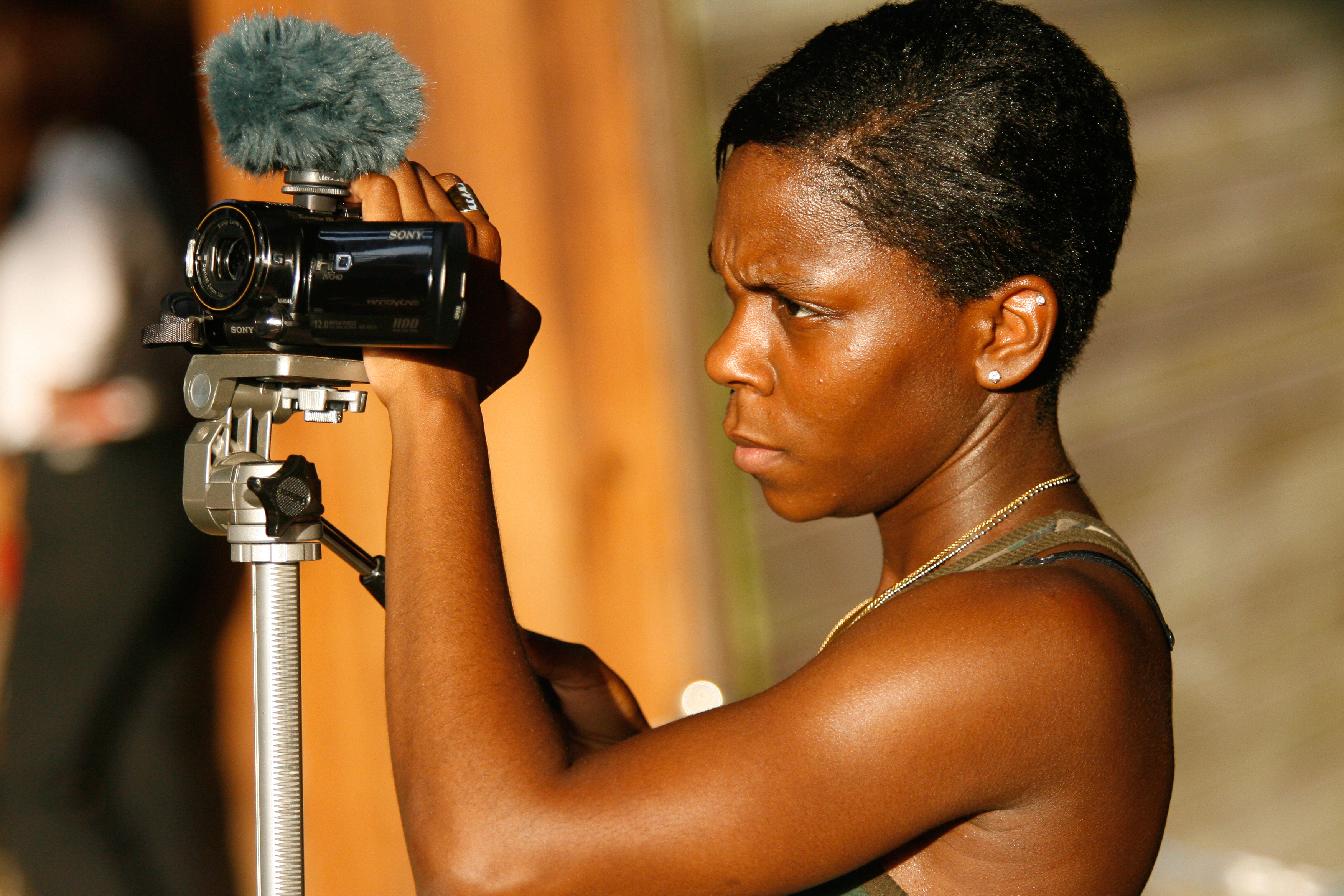 a wolf trap intern is shown operating a handheld digital camera filming an event