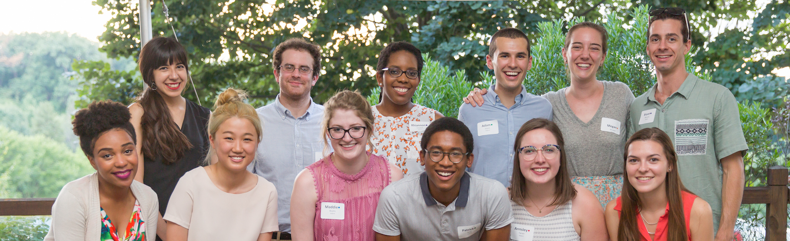twelve diverse wolf trap interns are standing together for a group picture in front green trees