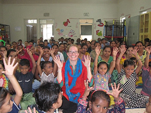 Photo of a Wolf Trap Teaching Artist surrounded by students in India