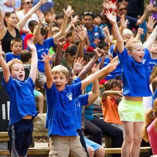 Photo of elementary school children dancing during a performance at Children’s Theatre-in-the-Woods