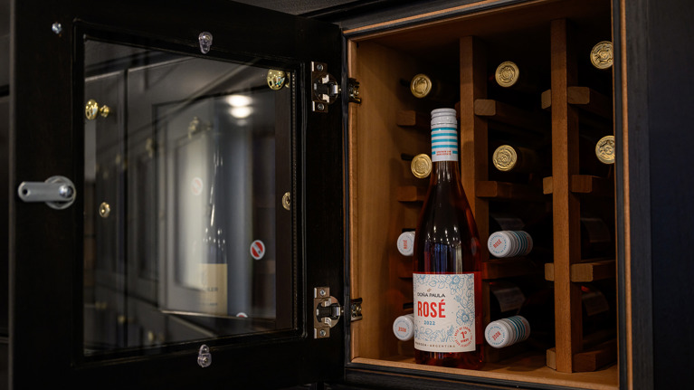 A Wolf Trap Wine Locker open, filled with bottles of wine, with one bottle upright on display.
