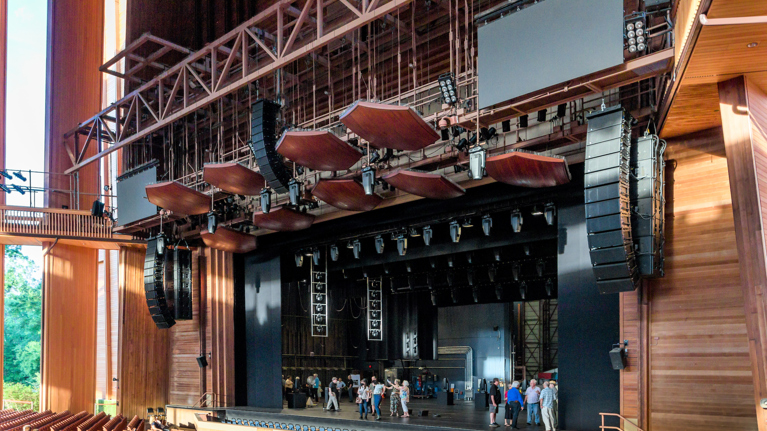 Wide stage view featuring new sound system with large speaker clusters and acoustic panels overhead.