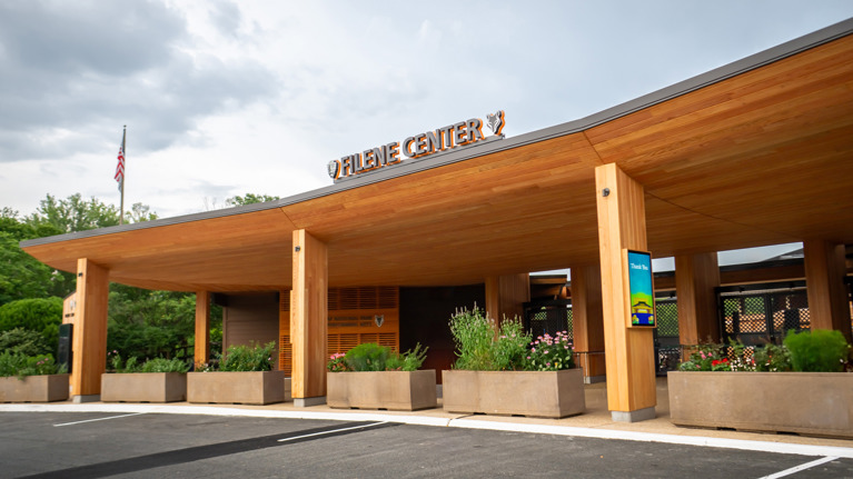 Renovated Filene Center main gate with wood-paneled structure, large planters, and clear signage.