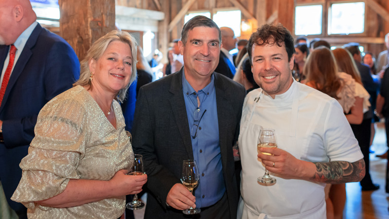 Guests mingling with wine glasses.