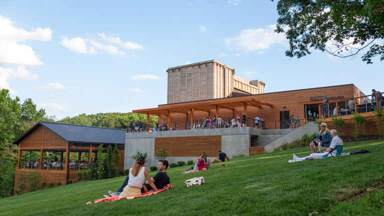 Meadow Commons seen from the Meadow with guests relaxing on picnic blankets on the grass.