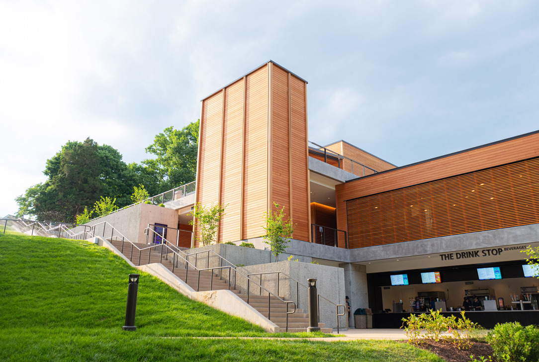 Lower-level view of Meadow Commons showing “Drink Stop” counter, stairs, and landscaped slope.