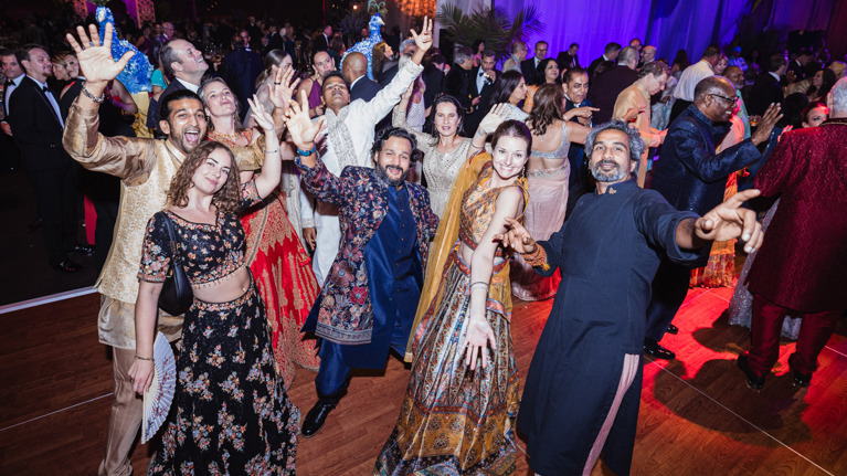 Guests in colorful Indian-inspired formal attire dance at the Wolf Trap Ball.