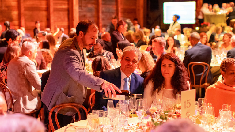 Wine being poured at a dinner table.