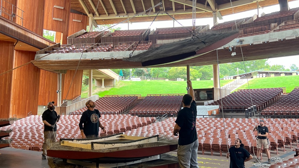 Stagehands set up hexagonal sound panels above the stage. (Photo credit: Ryan Haderlie)
