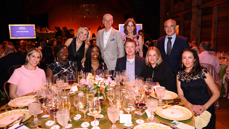 Group gathered around a formal dinner table.