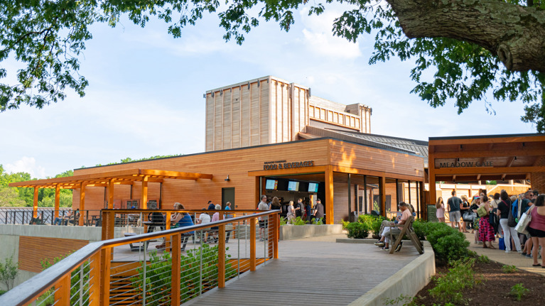Elevated pathway leading to Meadow Commons with landscaped greenery and outdoor seating.