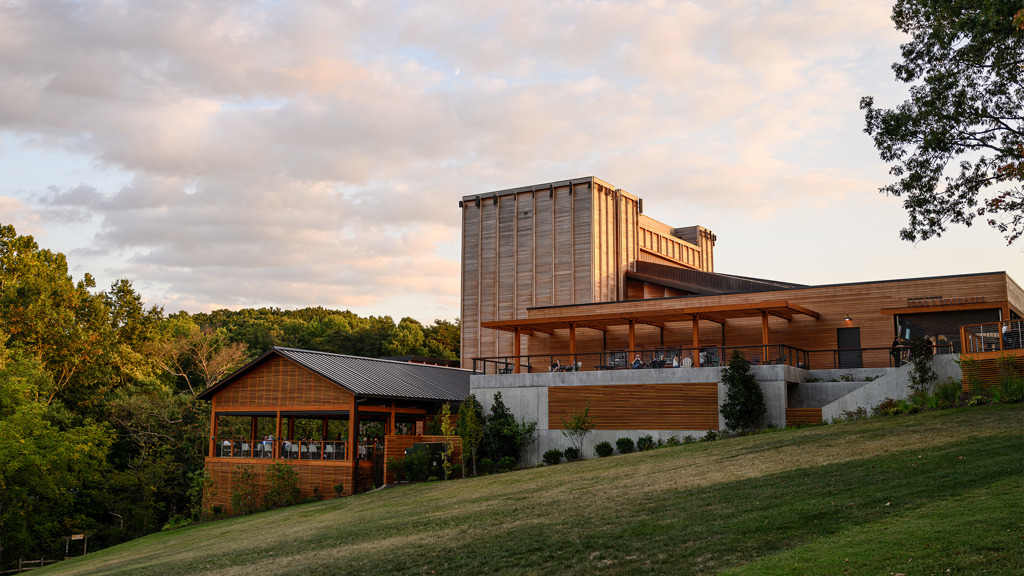 The Filene Center and Meadow Commons, angular wooden buildings, on a grassy hill surrounded by trees.