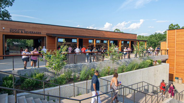 Exterior view of Meadow Commons with concessions windows, landscaped walkway, and terraced stairway.
