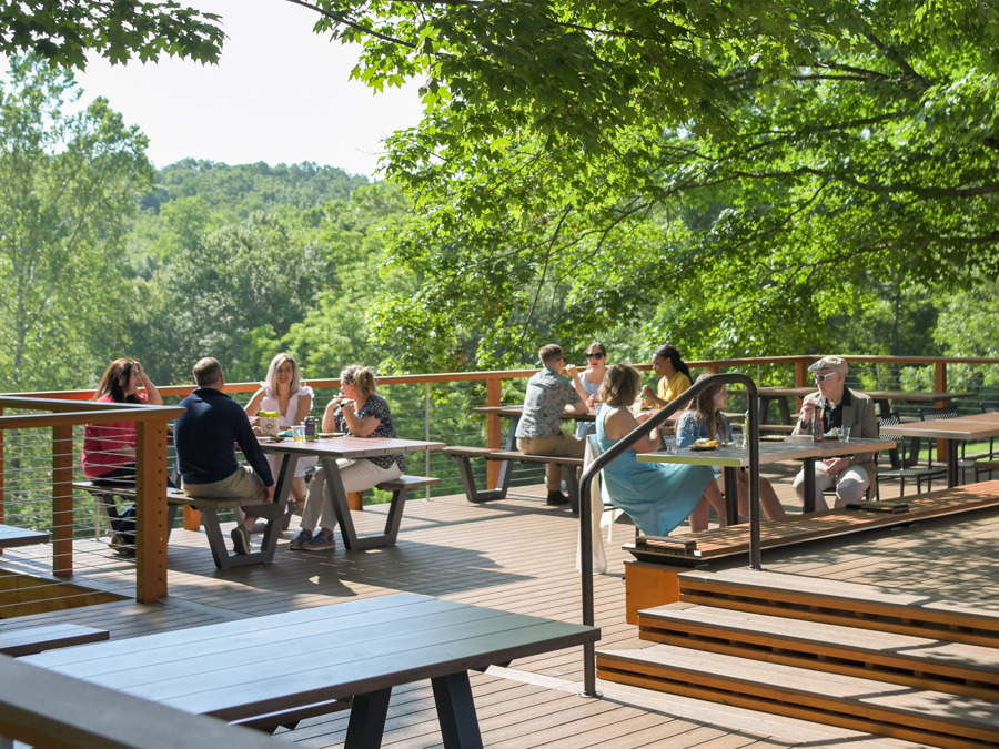 Meadow Overlook: Change from a picnic area under trees to a raised wooden deck with tables overlooking scenic greenery.