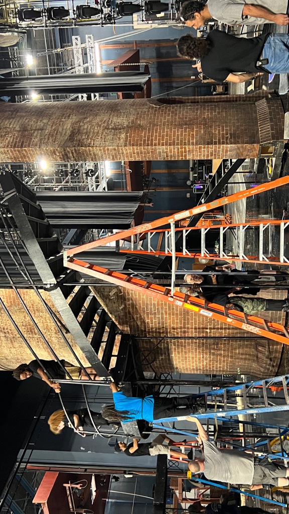 Stagehands set up a tower and chandelier set piece for Wolf Trap Opera’s 2023 production of Don Giovanni (Photo credit: Ryan Haderlie)